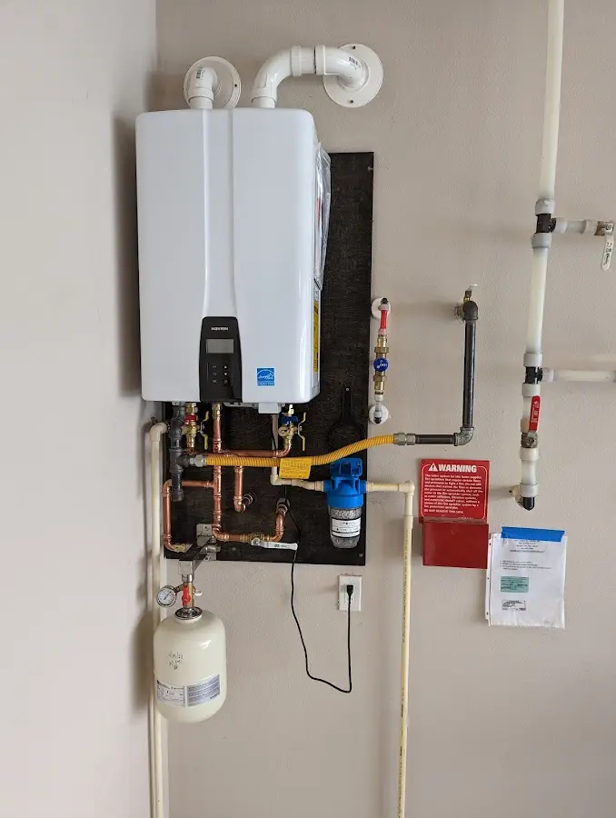 Professional plumber installing copper piping in a Chalco home